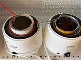 two jars of liquid sitting on top of a stove