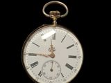a gold pocket watch with roman numerals on the face