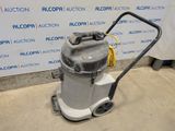 the vacuum is sitting on the floor in front of the wall