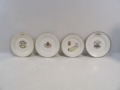 quatre assiettes aux motifs variés sont alignées sur une surface blanche