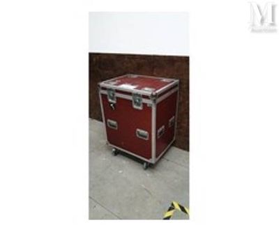 une image montrant une valise rouge posée sur un sol en béton