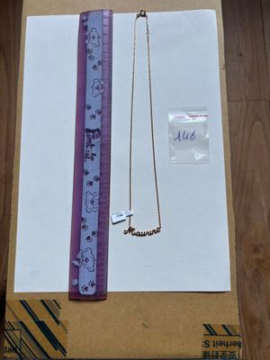 une boîte sur laquelle sont représentés un collier et une règle, posée sur une table