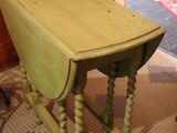 a small table with a drop leaf on it in a room