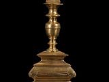 an antique brass candle holder on a black background with a black background
