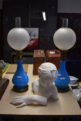 une statue représentant une femme assise sur une table, à côté de deux vases bleus