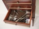 a wooden box with silverware in it on the floor