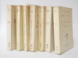 six books are lined up in a row on a white surface
