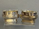 two glass containers sitting on a clear stand