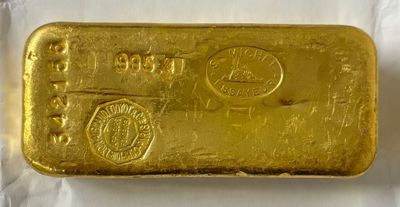 gros plan d'un lingot d'or sur une surface blanche