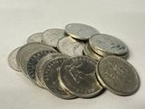 a pile of coins sitting on a white surface