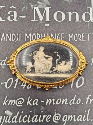 une photo d'une broche en or représentant un homme à cheval