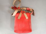 a small red bag with a gold bow on it
