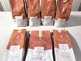 six bags of coffee sitting on top of a table next to each other