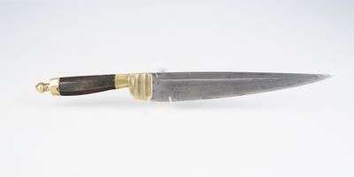 un gros plan d'un couteau posé sur une surface blanche, avec un manche doré