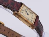 an image of a close up of a wrist watch with a brown strap