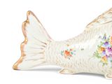 a fish shaped container with flowers painted on it