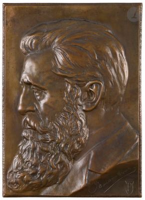 a close up of a bronze plaque of a bearded man