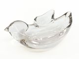 a glass bowl with a bird on it on a white surface