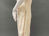 an image of a mannequin wearing a beige dress and hat