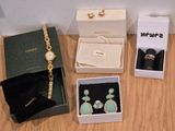 une boîte à bijoux posée sur une table, à côté d'une paire de boucles d'oreilles et d'une montre