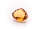 a close up of a faceted citrine gemstone on a white background