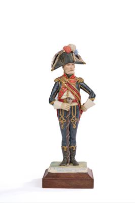 figurine of a man in a military uniform standing on a wooden base