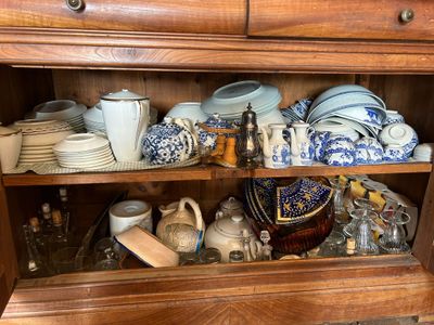 a wooden cabinet with a bunch of dishes and cups on it