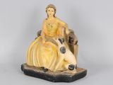 une figurine représentant une femme assise sur le dos d'une vache