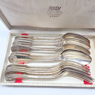 des couverts dans un coffret en argent avec des poignées rouges et des poignées rouges