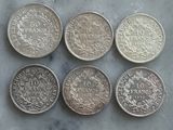 six types différents de pièces d'argent posées sur une table