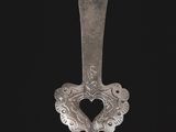 une vieille cuillère en argent avec un manche, sur fond noir
