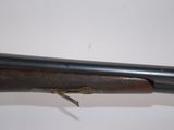 a rifle with a wooden barrel and a metal handle