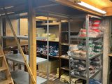 a room with shelves, shelves, and a ladder in it