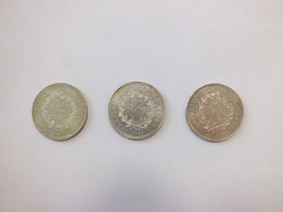 three different british coins sitting on top of a white surface