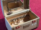 an open suitcase on a pink surface with a pair of scissors in it