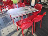red chairs and a table on the deck of a house