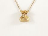 a close up of a gold necklace with a bag of money on it