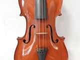 a close up of a violin sitting on a white surface