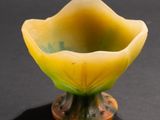 a small yellow bowl sitting on top of a black table