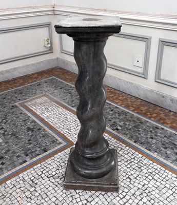 un socle en marbre au milieu d'un sol carrelé