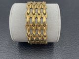 a close up of a gold bracelet on top of a white ring
