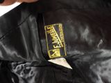 the back of a black leather jacket with a yellow label on it