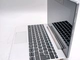 a white laptop with a black keyboard on a white surface