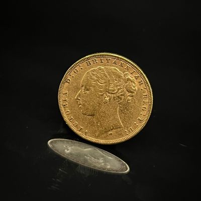 l'image d'une pièce d'or à côté d'une pièce, sur un fond noir