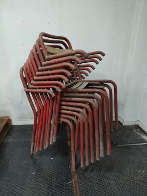 a stack of red chairs sitting on top of a black mat