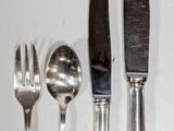 four forks, a knife, and a spoon on a table