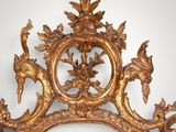 a mirror that has a gold frame with birds on it
