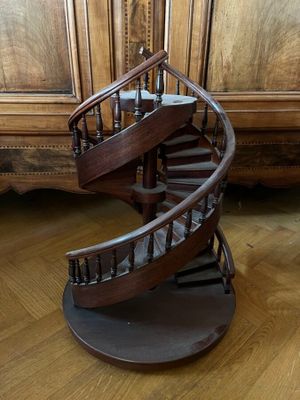 a wooden spiral staircase in the middle of a room
