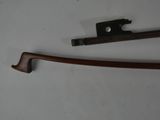 a close up of a bow and a bow rest on a white surface