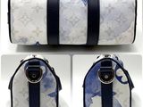 a picture of a blue and white bag with a black strap